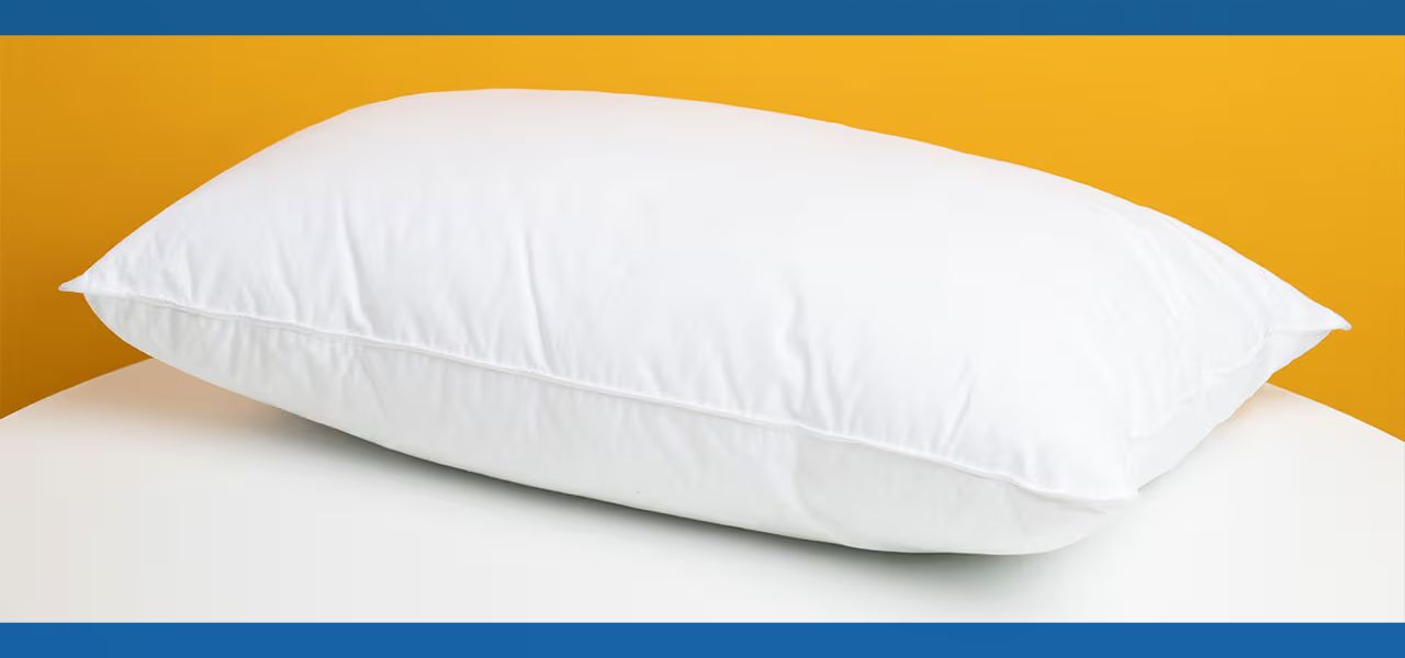 A white pillow on a light surface with a yellow background.