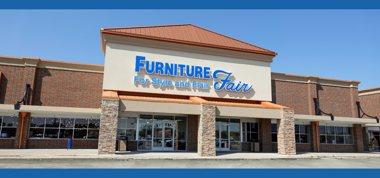Furniture store exterior with large sign and clear blue sky.