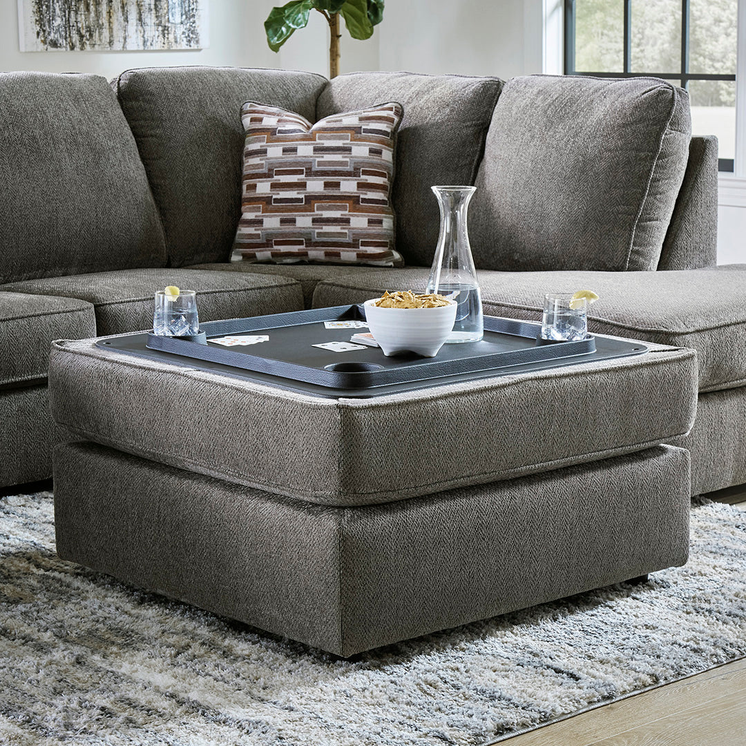 Gray sectional sofa with a coffee table extension in a living room setting.