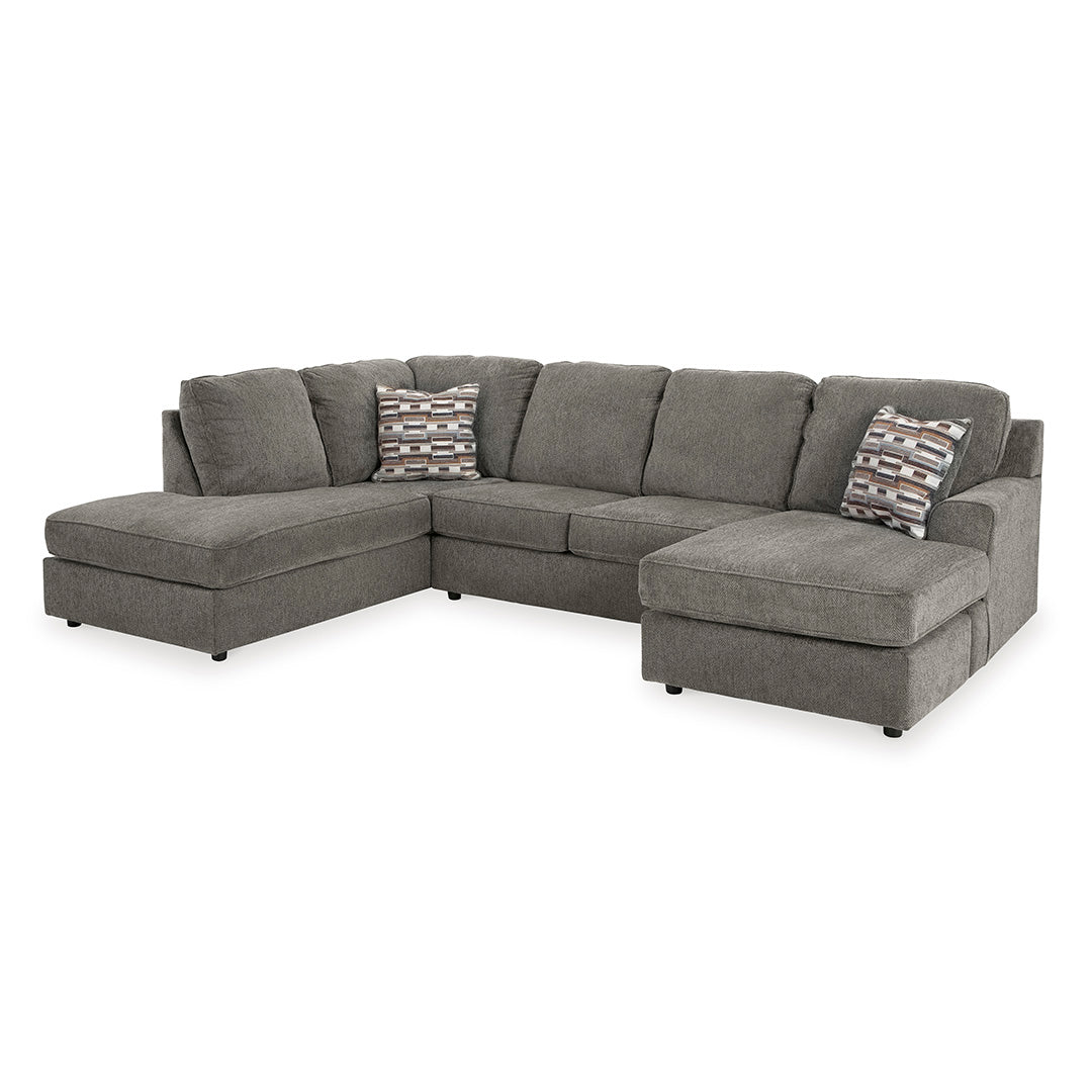 Gray sectional sofa by ashley furniture with patterned cushions on a white background