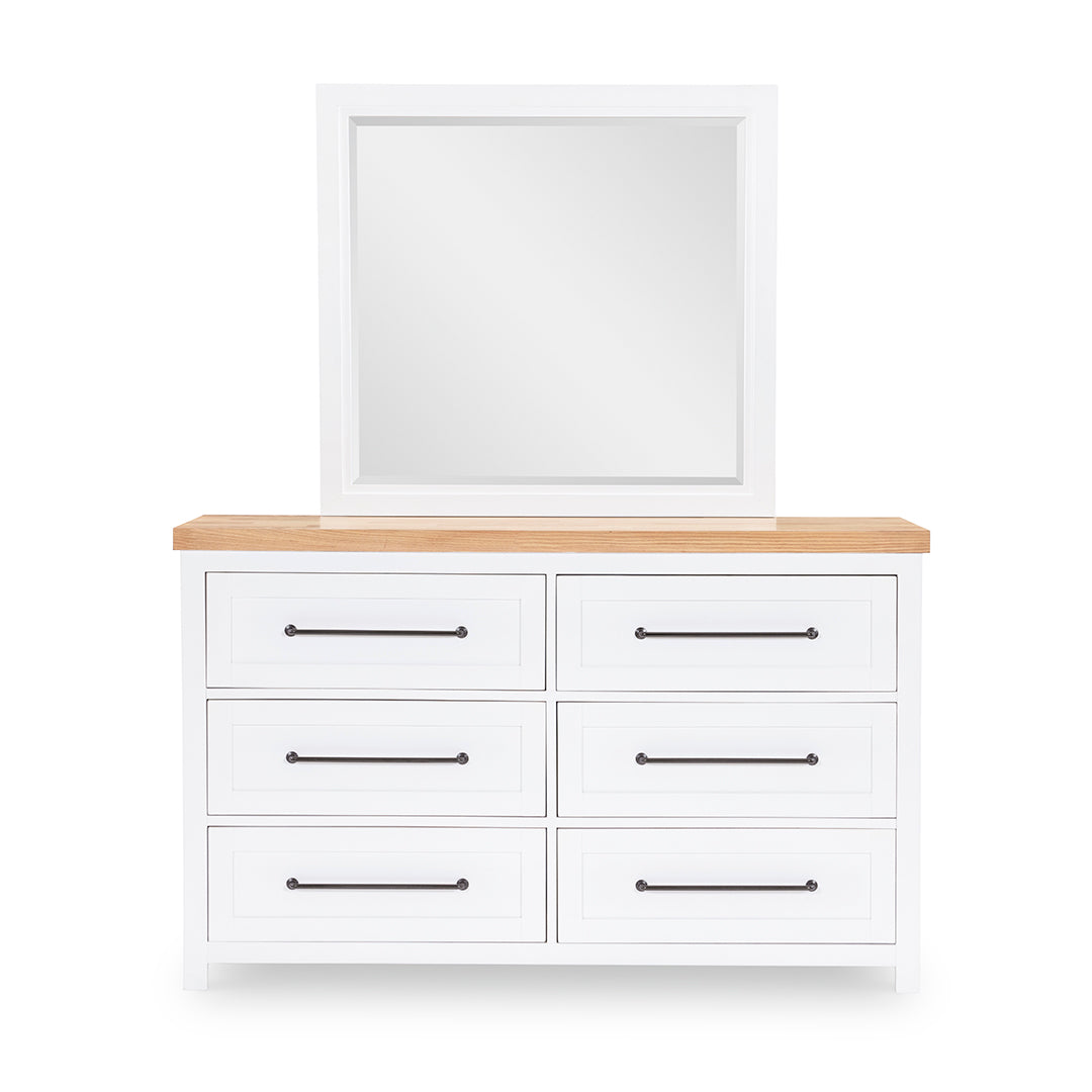 White dresser with six drawers and a wooden top on a white background