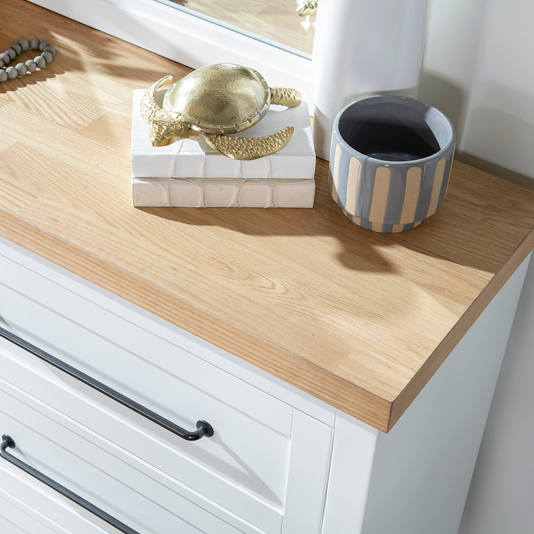 Decorative items on a wooden surface with white cabinets below