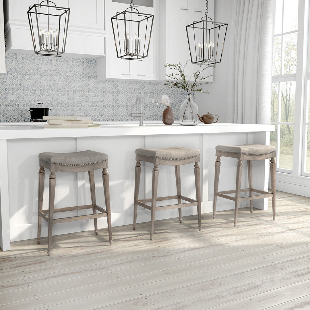 Three bar stools in a kitchen setting with pendant lights and a window.