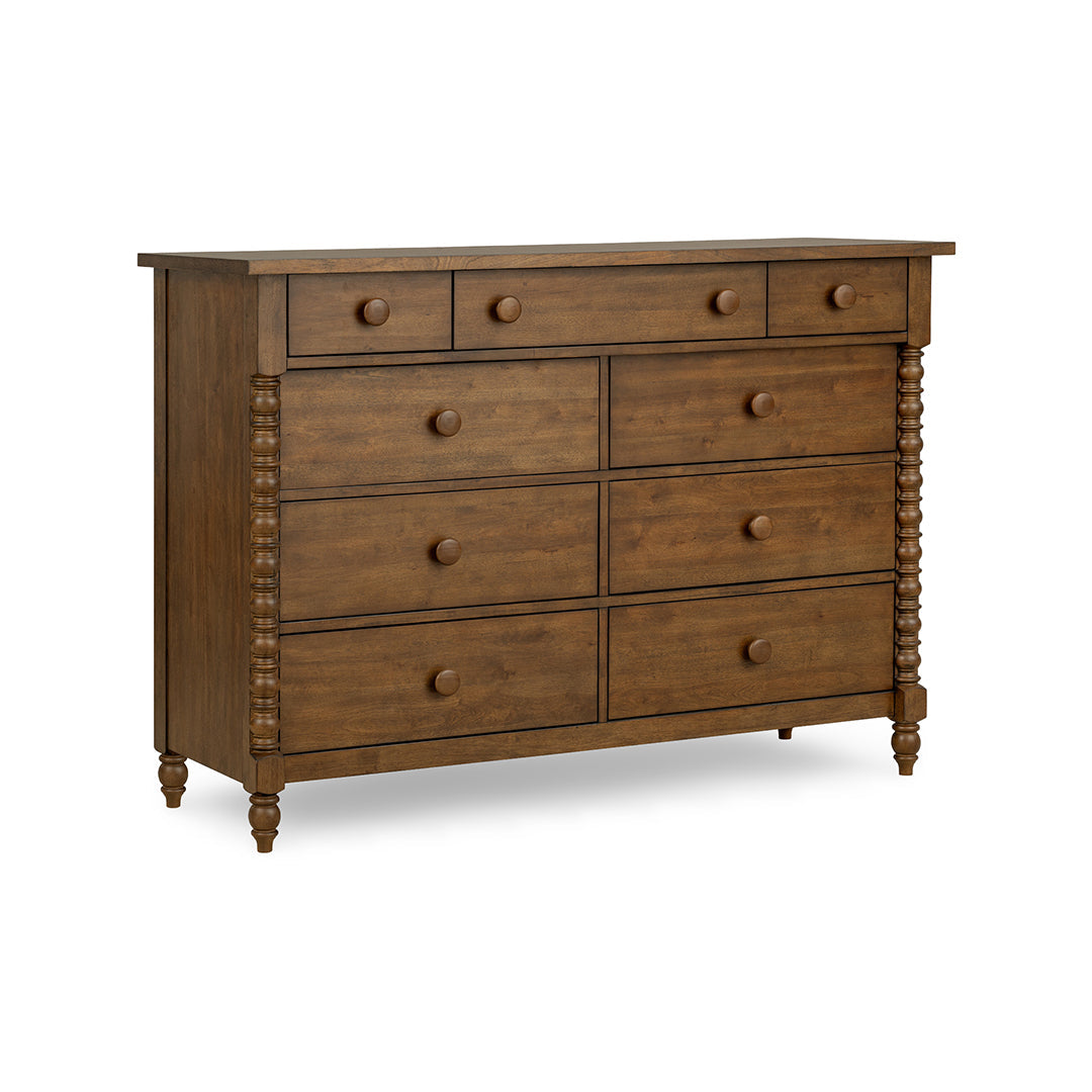A rustic brown wooden dresser with eight drawers, featuring turned spindle-style side posts and round drawer knobs.