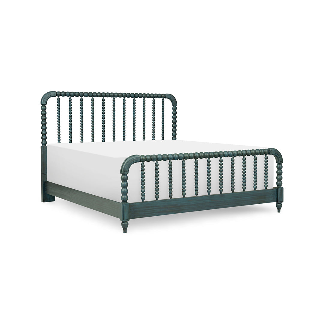 A dark green spindle-back bed frame with a white mattress
