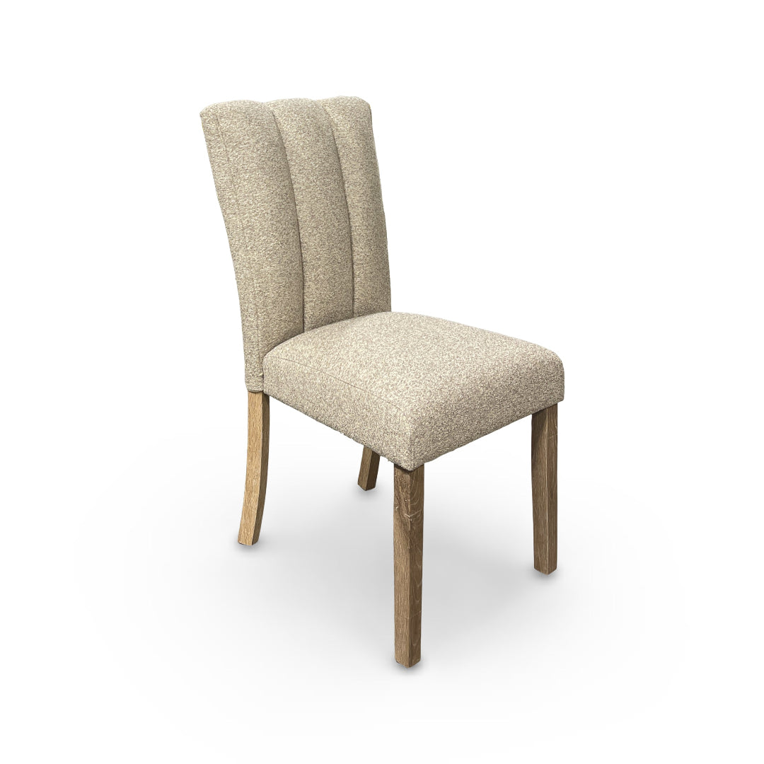 Beige upholstered chair with wooden legs on a white background