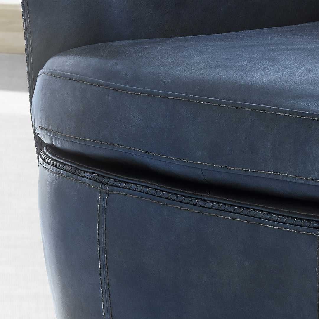 Close-up of a blue leather armchair with visible stitching details.