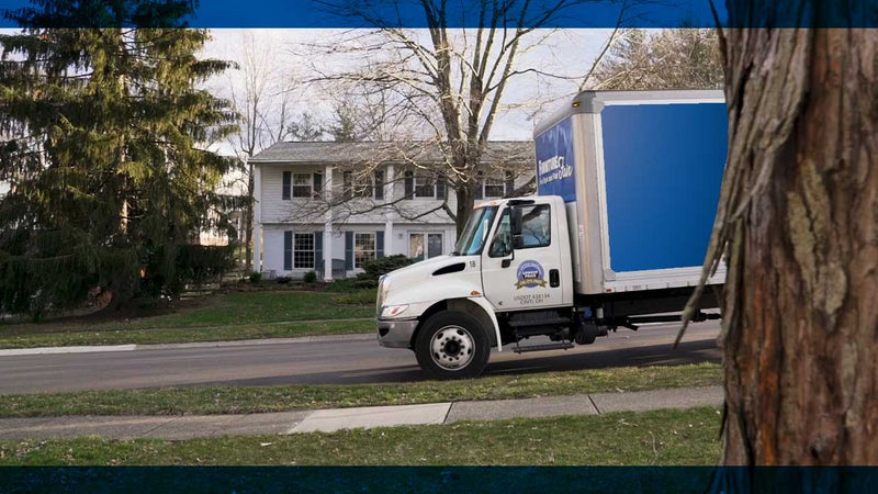 Furniture Fair dedicated in-house delivery truck delivering and setting up furniture in a local residential neighborhood