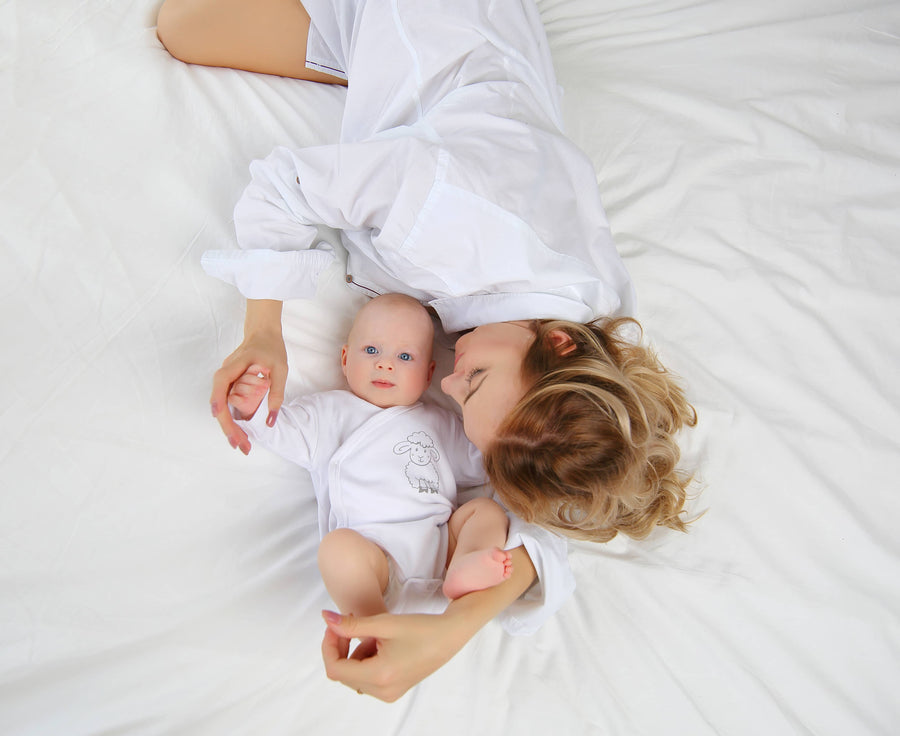 Mother and baby relaxing together on a comfortable bed in a cozy bedroom