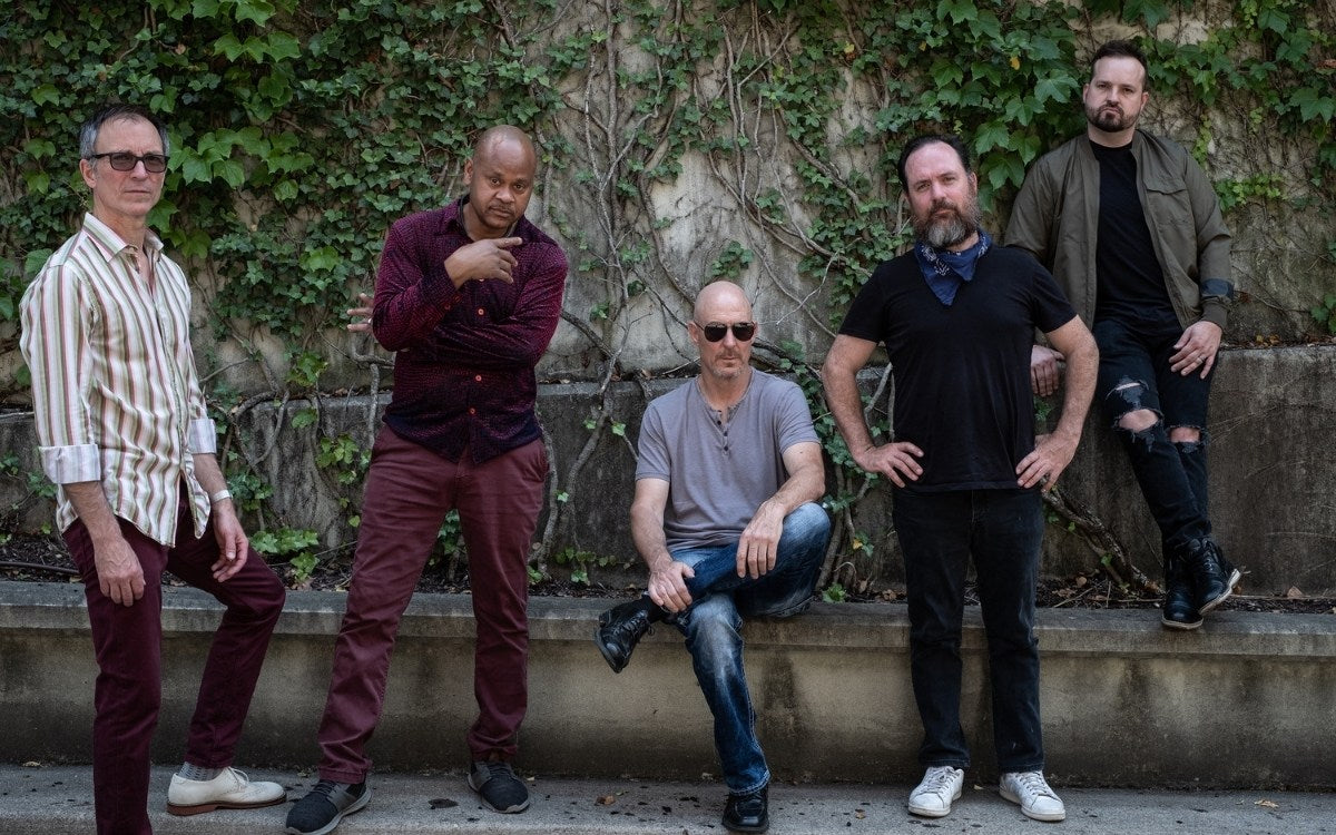 Blessid Union of Souls band members posing outdoors in front of a stone wall
