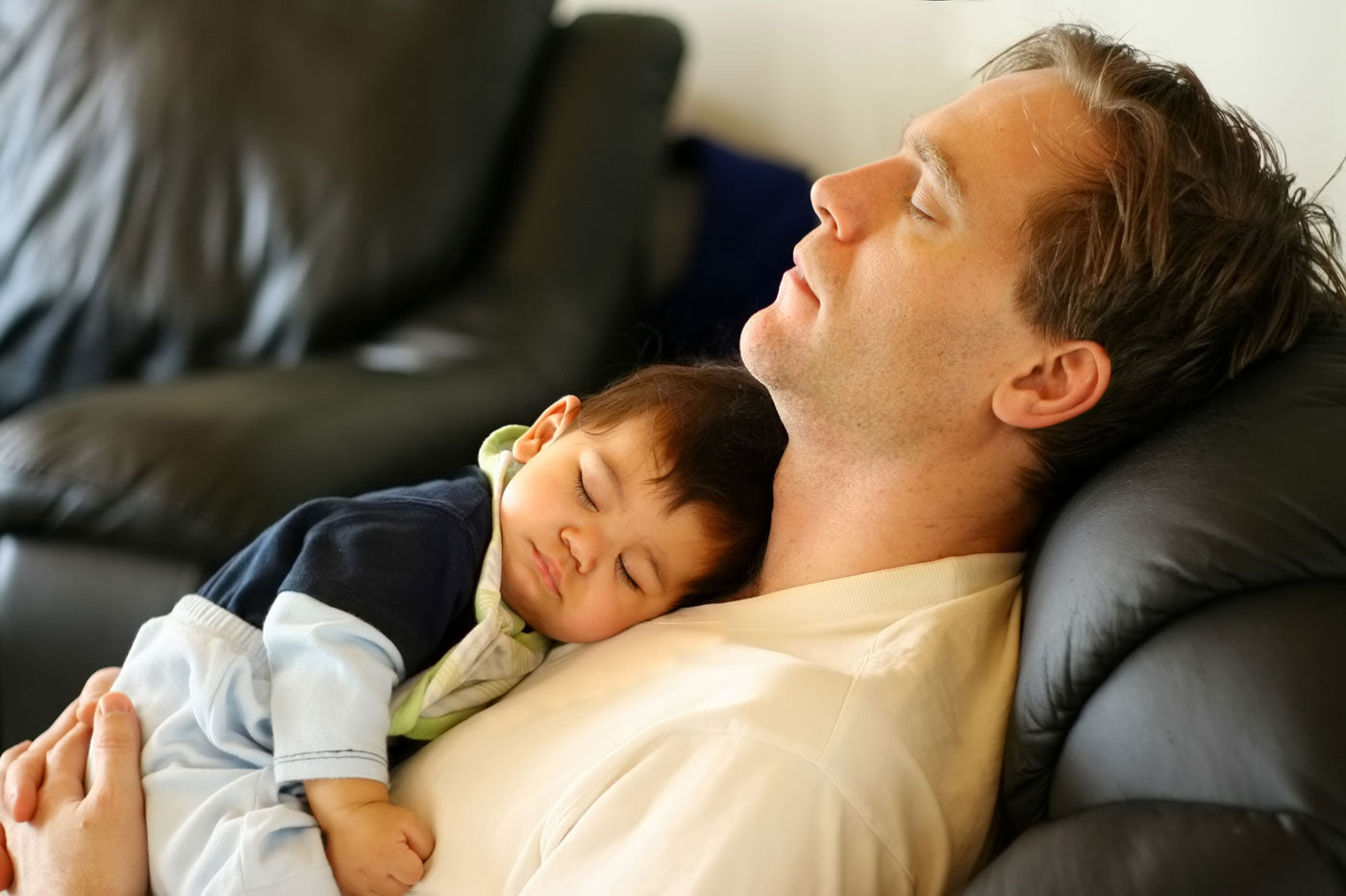 Father in recliner with baby sleeping