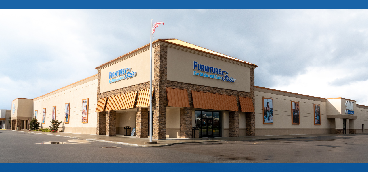Retail store exterior with blue sky and clouds.