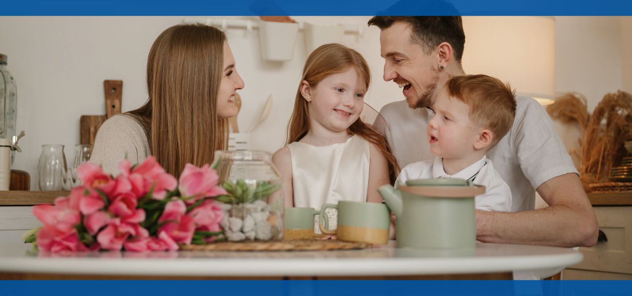 A family enjoying a meal together at a dining table with flowers.