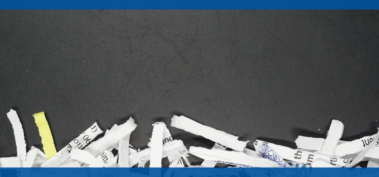 Shredded paper pieces scattered on a dark surface.