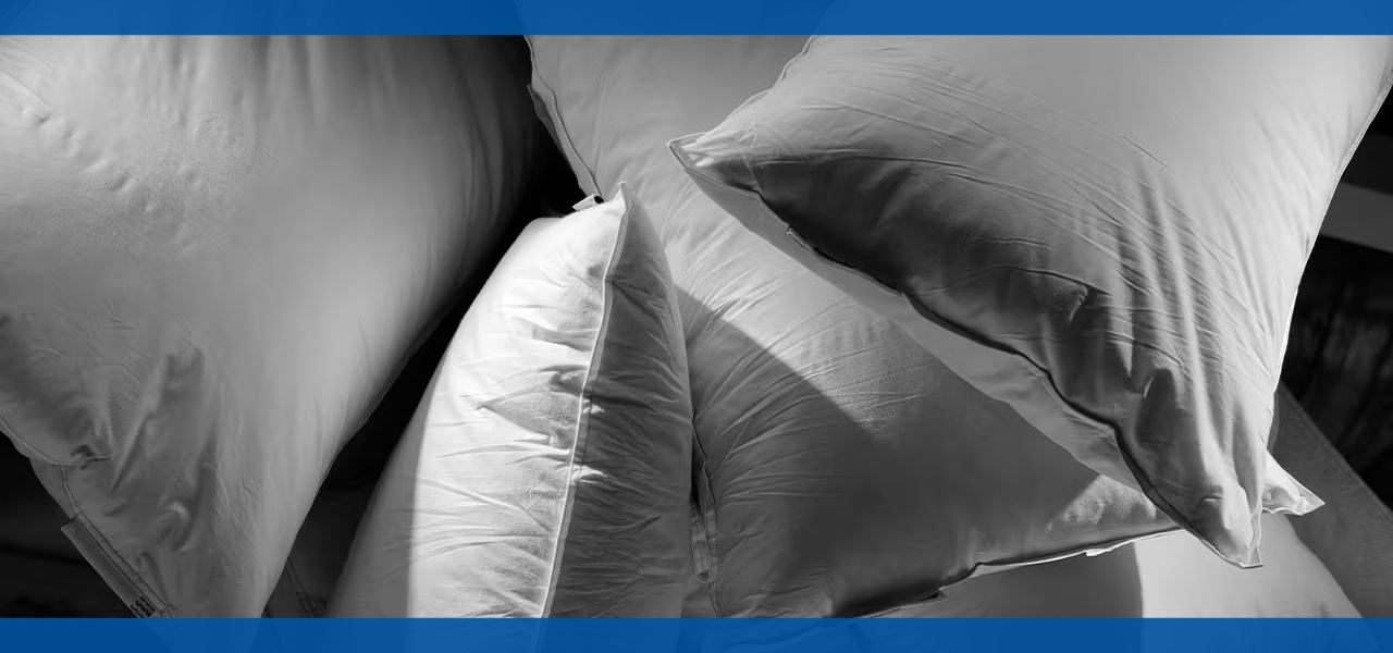 Several white pillows stacked together on a dark surface.