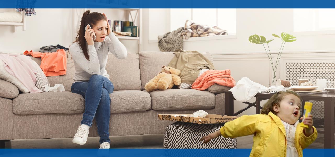 A woman sitting on a couch while a child plays nearby.