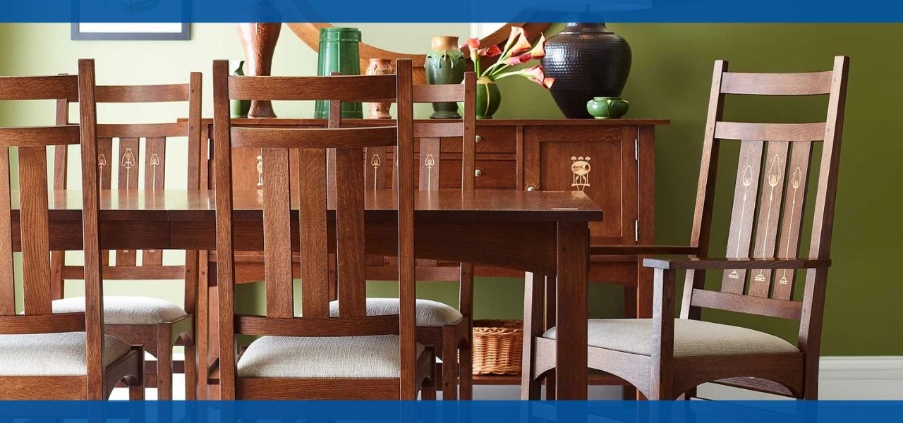 A wooden Stickley Harvey Ellis dining table with chairs against a green wall.