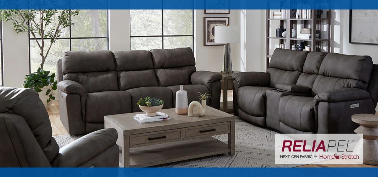 Family relaxing on gray reclining furniture with their dog in a cozy living room, illustrating everyday life with Reliapel performance fabric upholstery