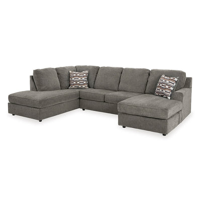 Gray sectional sofa by ashley furniture with patterned cushions on a white background