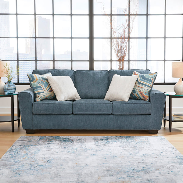 Blue sofa with decorative pillows in a living room setting