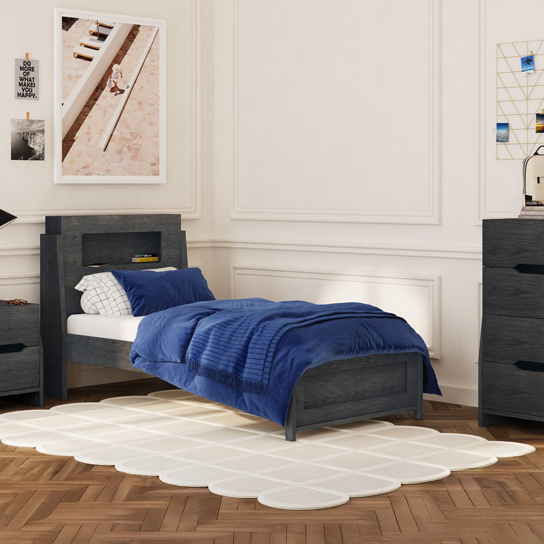 Bedroom with a bed covered in blue bedding, gray headboard, and white walls.