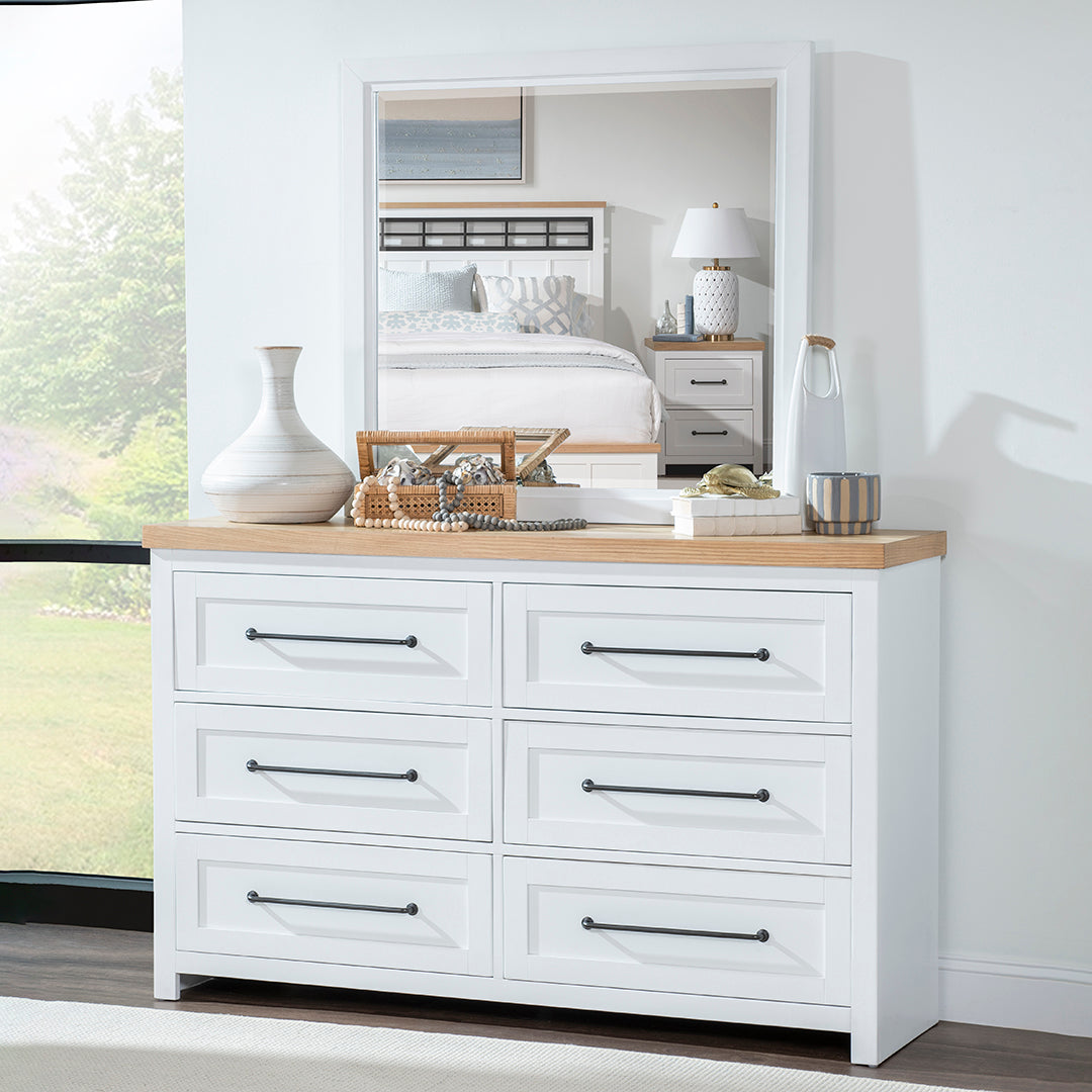 White dresser with wooden top in a bedroom setting