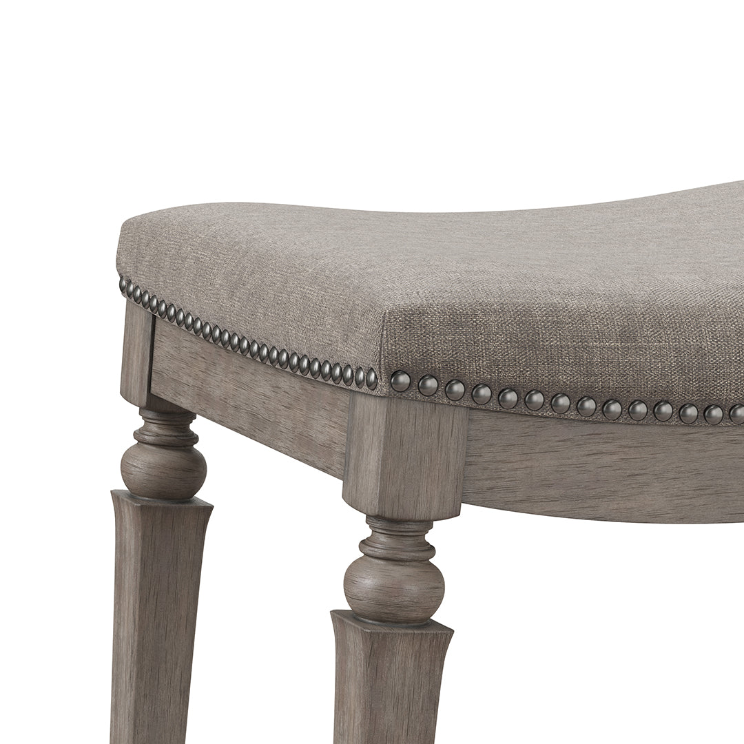 Close-up of a upholstered chair with wooden legs and nailhead trim on a white background