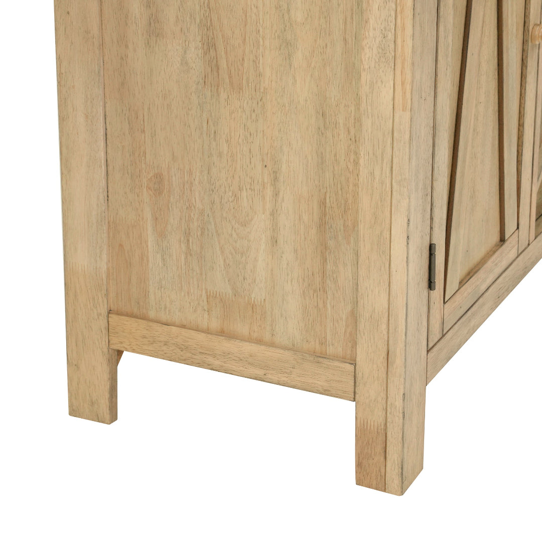 Close-up of a light natural wood cabinet or sideboard showing the front panel, grain texture, lower leg, and part of the door with a dark metal hinge on a white background.