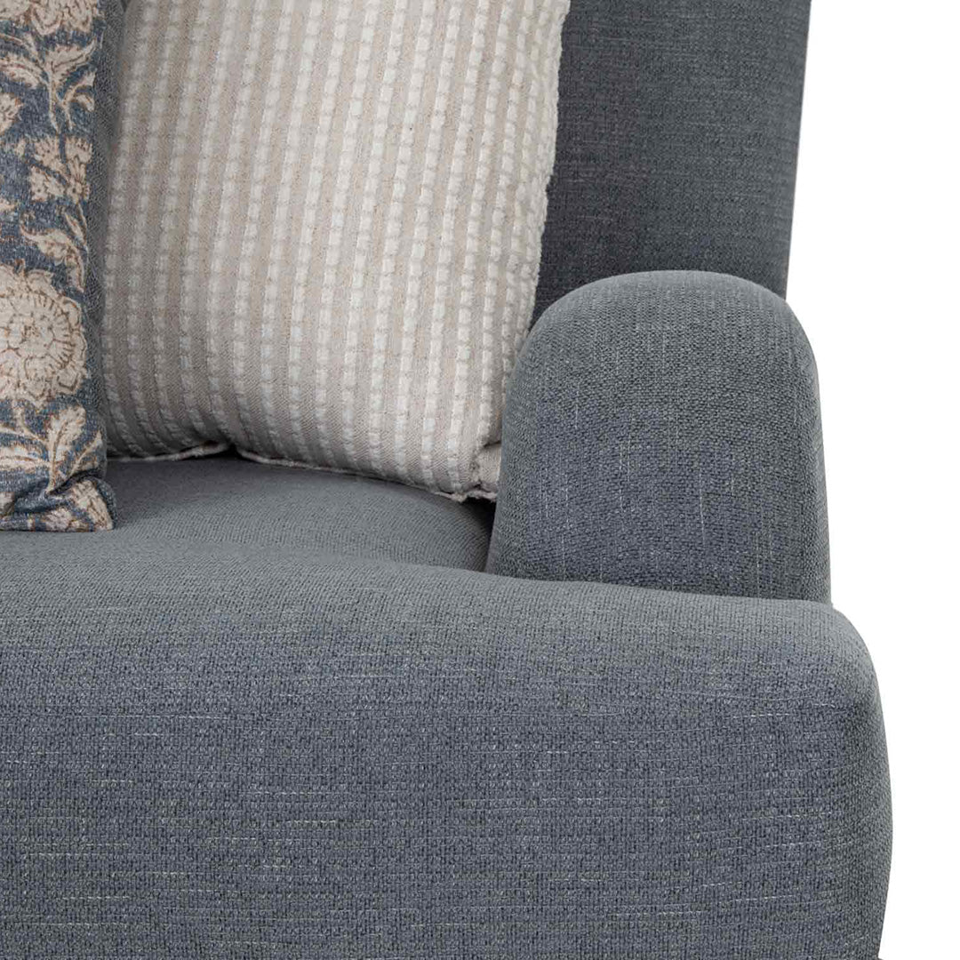 Gray upholstered chair with patterned cushions on a white background