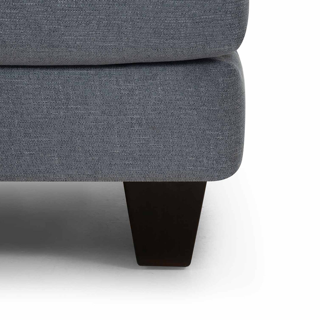 Gray upholstered chair with a dark wooden leg on a white background