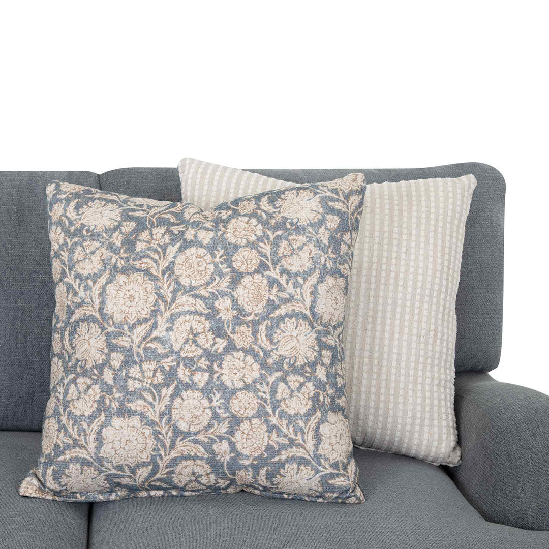 Floral patterned pillow and textured pillow on a gray sofa