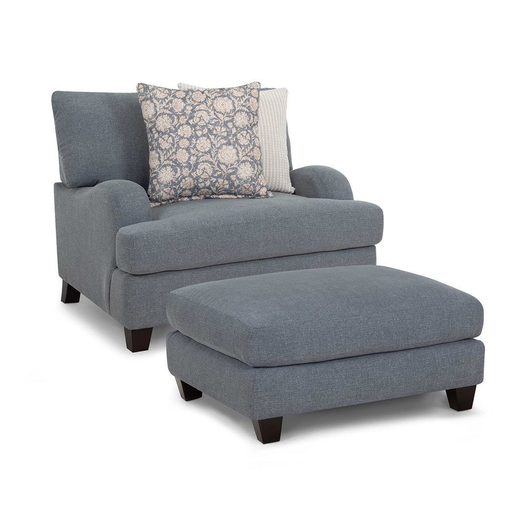 Gray armchair with ottoman and decorative pillows on a white background