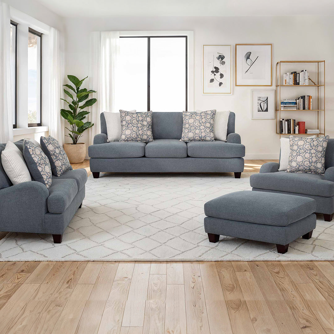 Gray sofa set with matching armchair, ottoman, and decorative pillows in a living room setting.