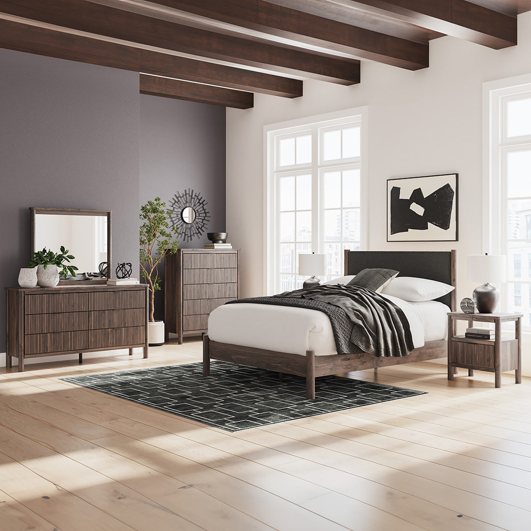Modern bedroom with bed, dresser, chest, nightstand, and decor elements. 