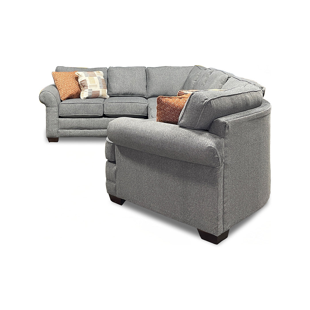 Gray sectional sofa with brown and beige cushions on a white background