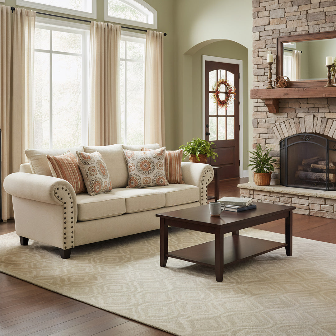 Living room featuring a roll-arm sofa positioned perpendicular to a stone fireplace around a central coffee table on an area rug