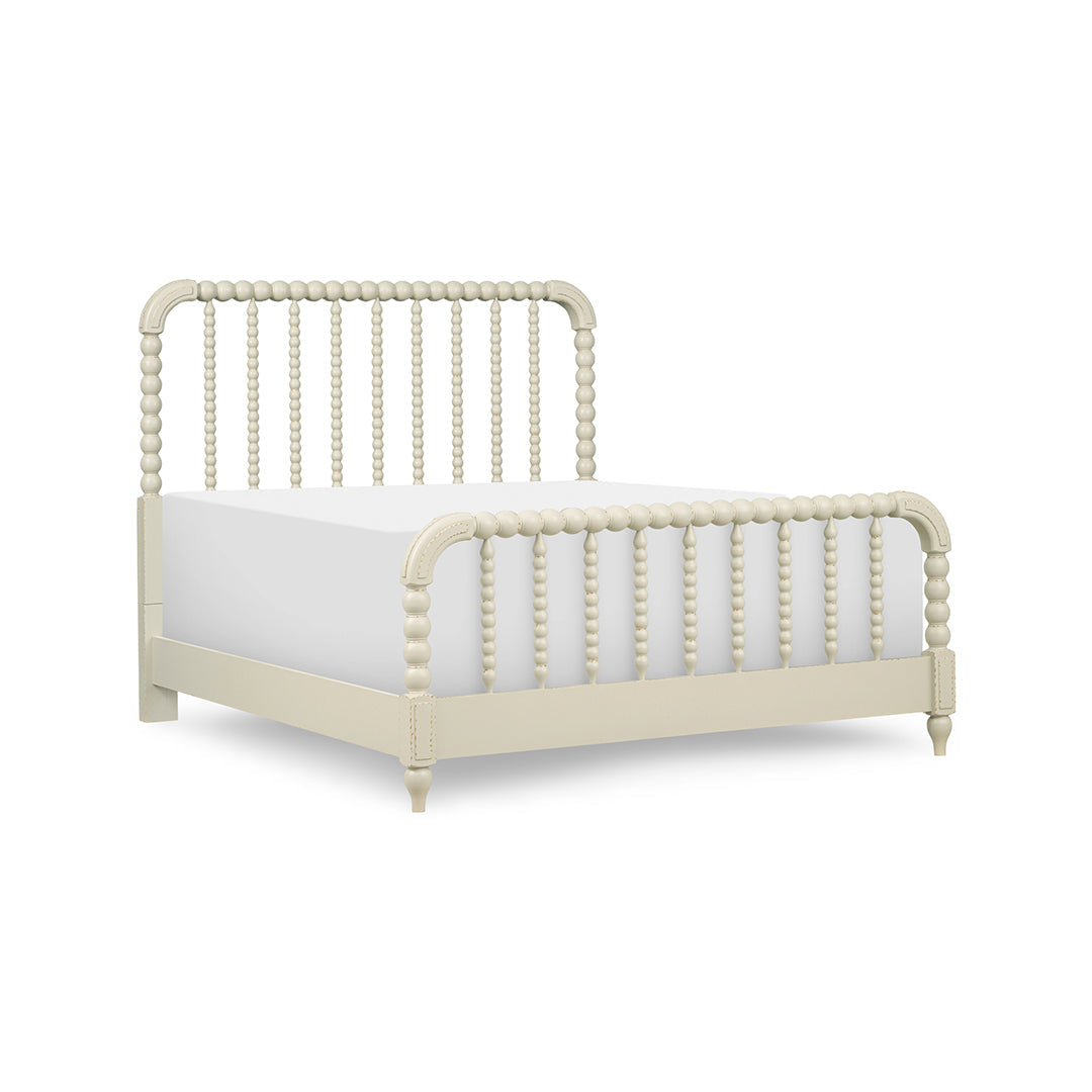 A cream-colored spindle bed frame with a matching headboard and footboard, shown with a white mattress.