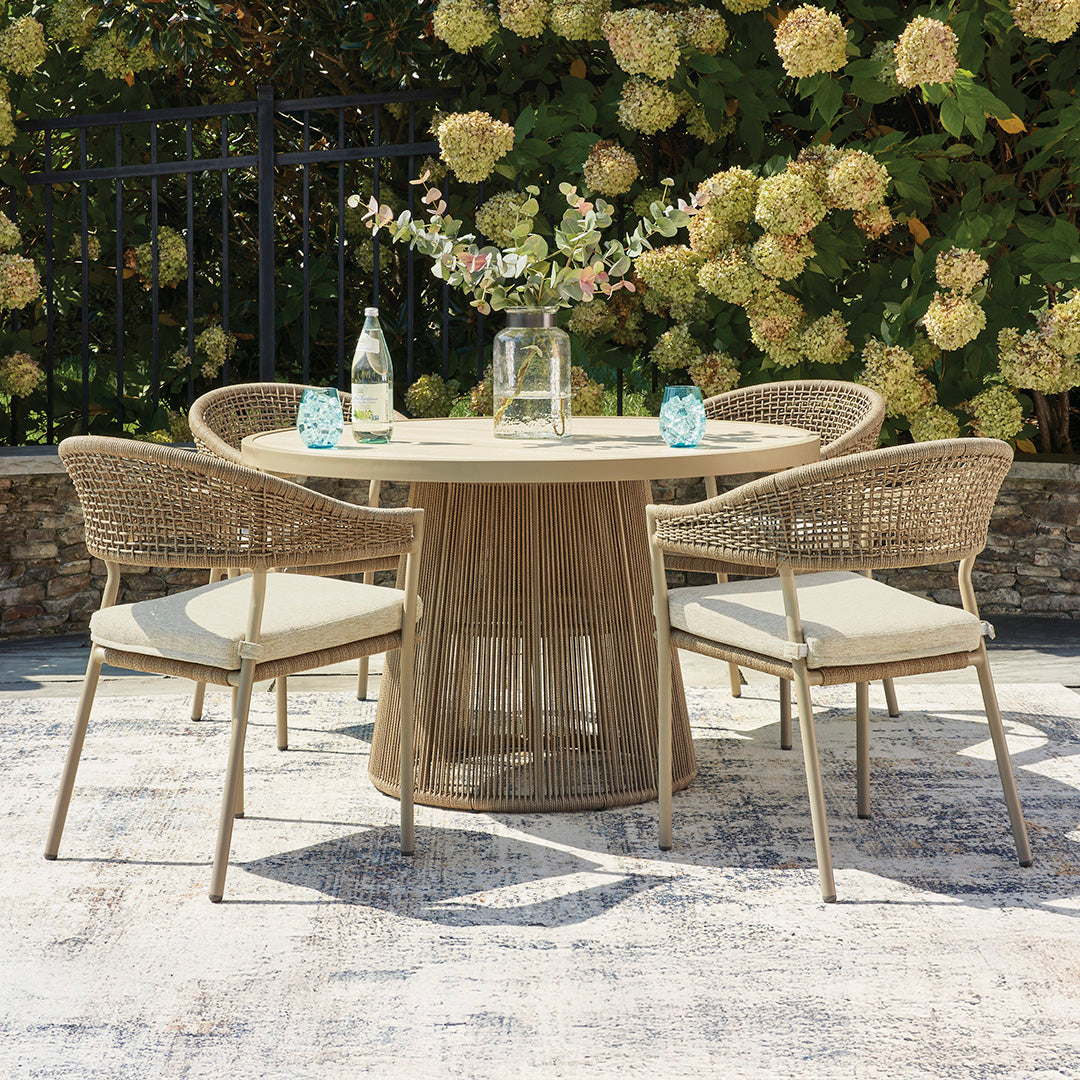 Round outdoor table with four matching chairs on a patio