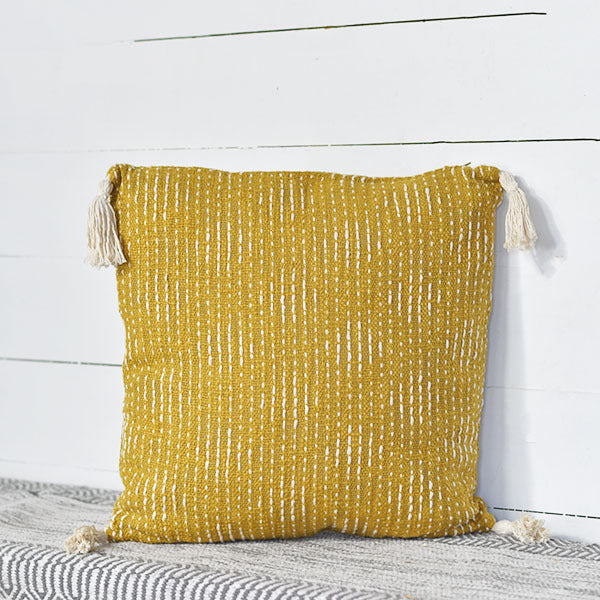 Almohada mostaza con borlas 