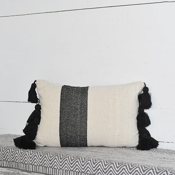 Almohada con borlas en blanco y negro 