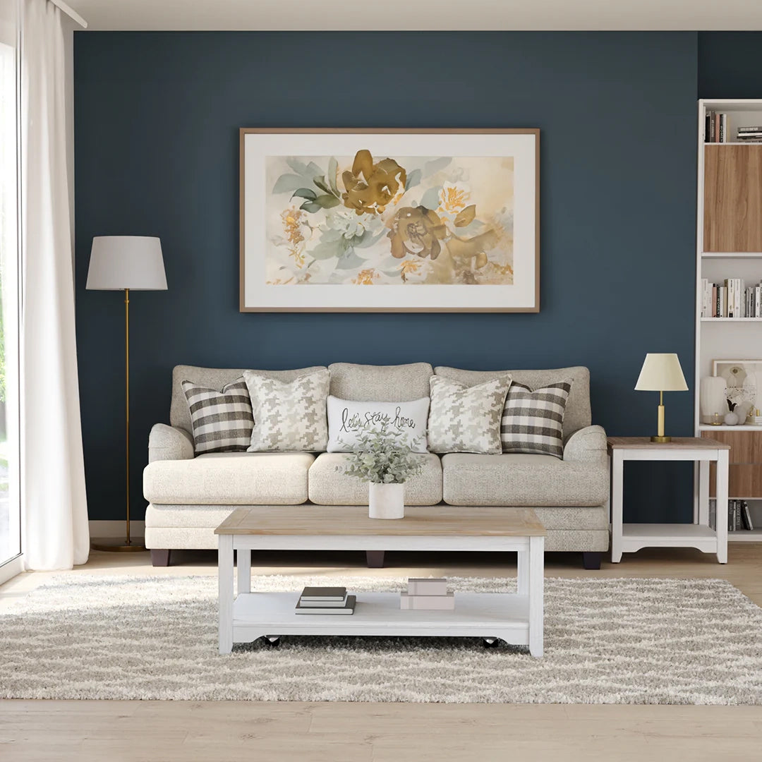 Living room with a gray sofa, coffee table, and decorative elements against a dark blue wall.