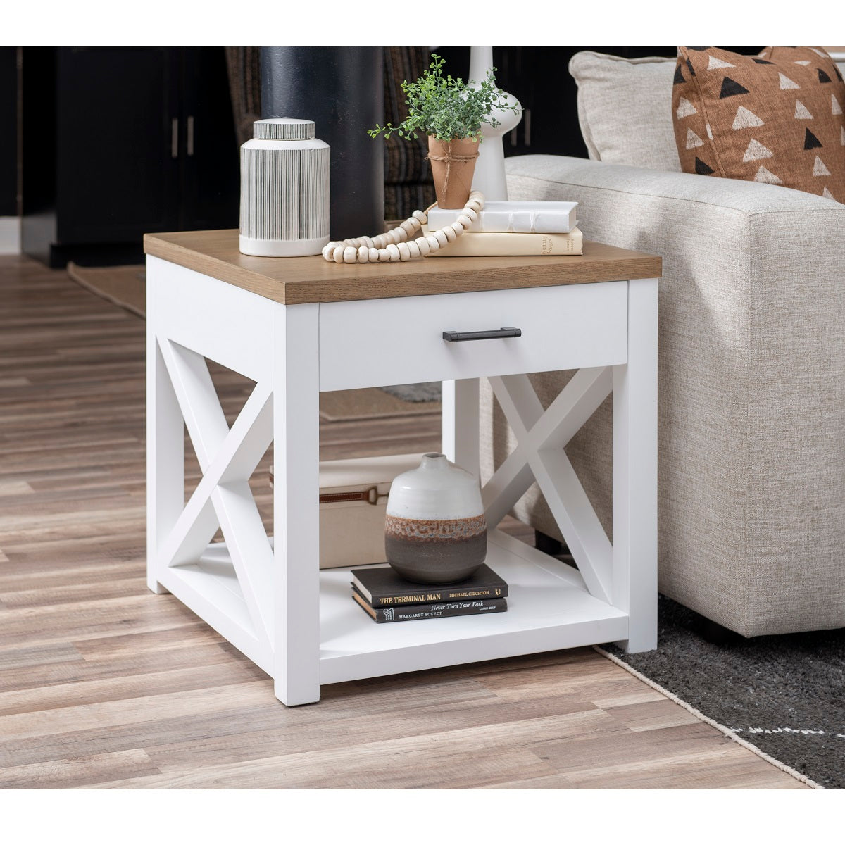 Franklin End Table. Harvest oak top on white oak veneer attached to a painted white base. X motif throughout entire collection. One drawer with aged matte black handle. One shelf. 