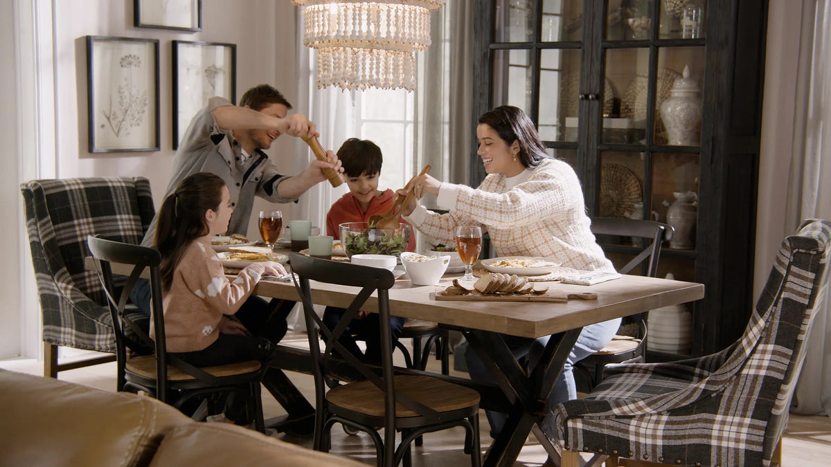 Family of four seated together enjoying dinner at an extended wood dining table