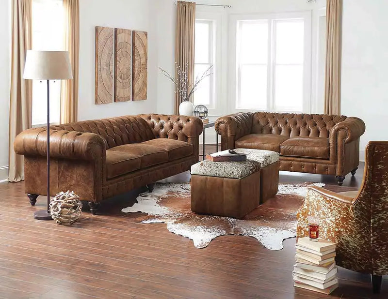 Dark brown leather sofa and armchair with nailhead trim near a white brick fireplace in a formal living room