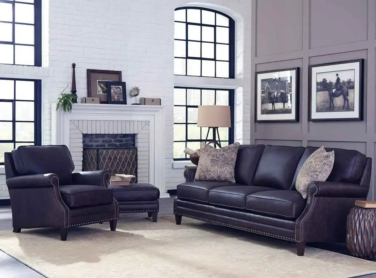 Warm tan leather sofa and matching armchair in a contemporary living room with charcoal accent walls