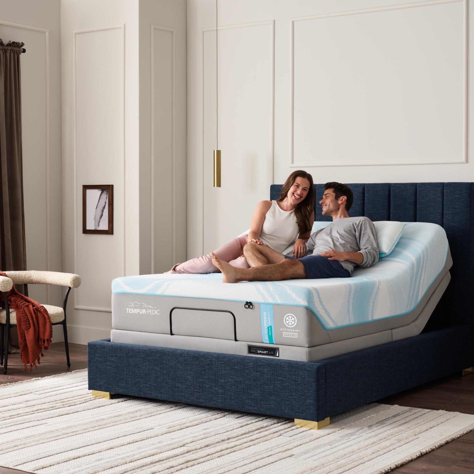 Couple relaxing on Tempur-Pedic adjustable bed in modern bedroom