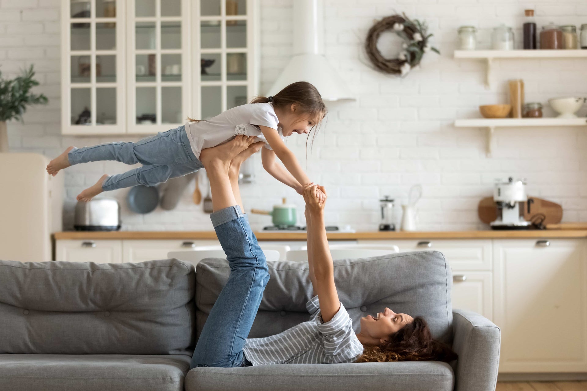 Mother and child playing together on a comfortable sofa