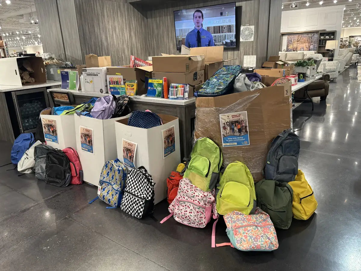 Rows of colorful filled backpacks and school supply boxes staged for donation pickup